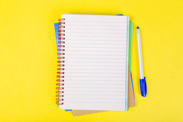 istock open spiral notepad on a yellow background with a pen. top view, stack of notepad with blank sheet. school concept, businessman work desk. 1314711491