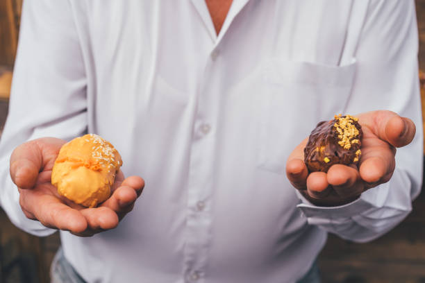istock The man holds eclairs in his hands. Concept choice. 1314713355