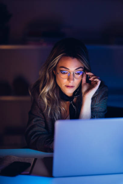 istock Focused businesswoman browsing laptop in night 1314714071