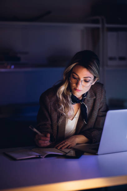 istock Serious blond woman working at desk in night 1314714072