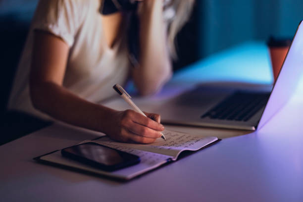 istock Faceless woman writing in notepad at table 1314714076