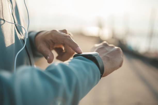 sport man checking at smartwatch during training and running in the park. stock photo