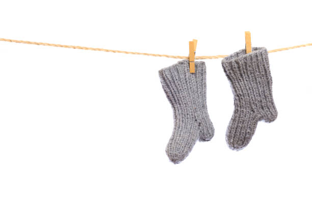 istock Baby clothes on a clothesline on white  background . knitted socks- Image 1314716291