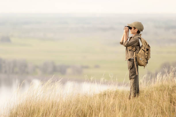 istock Boy with tourist on a cliff at sunset 1314717520