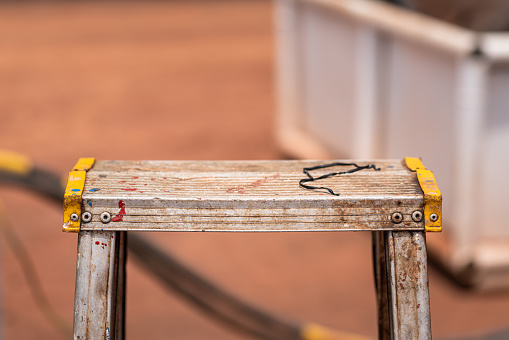 A-frame metal stepladder for construction working. Industrial equipment object, close-up and selective focus photo.