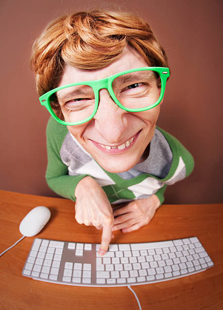 Close-up Of Nerdy Looking Guy Using The Computer stock photo