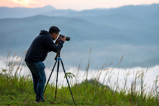 Travel photographer man captures nature footage of mountain landscapes at a scenic spot in Southern Thailand.