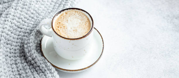 istock White mug with coffee and wool scarf on stone background. Winter composition in scandinavian style. Copy space for text 1314731326