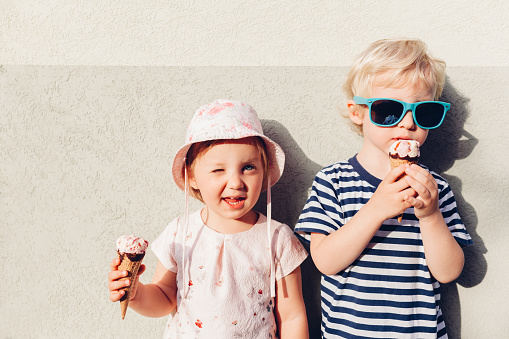 Adorable girl and boy eating ice cream.