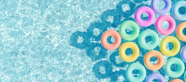 Photo of swimming pool seen from above with many rings floating
