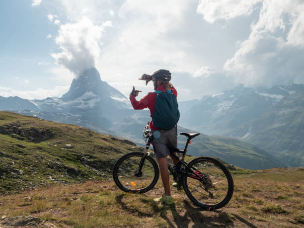istock Male mountain biker frames the Matterhorn mountain peak with hands 1314734986