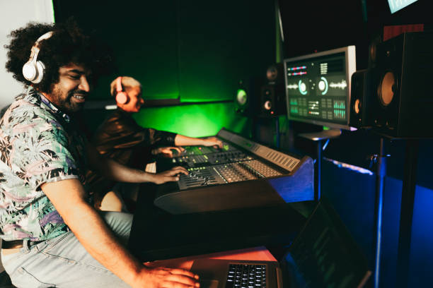 istock Audio engineers working on control desk panel for mixing new music album inside record studio - Focus on man face 1314735864