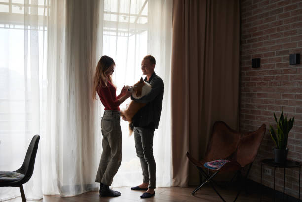 istock Beautiful young couple spending time with Corgi at home. 1314736701