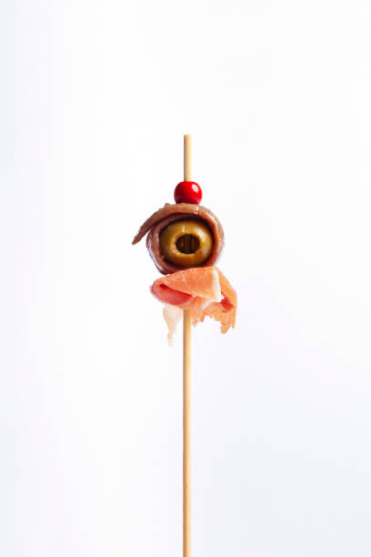 Canape with olive, anchovy fillet and serrano ham isolated Appetizer with olive, anchovy fillet and serrano ham banderilla stock pictures, royalty-free photos & images