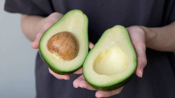 istock Avocado halves in female hands 1314738977