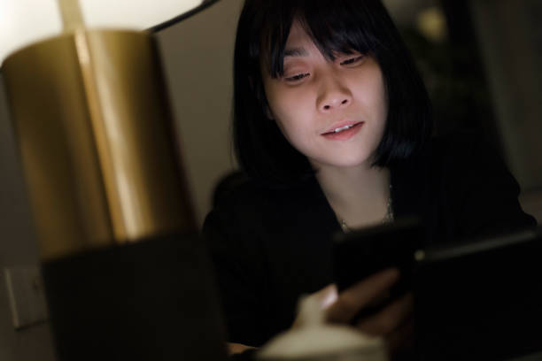 istock Young woman working from home using digital tablet while reading text message on mobile phone in the dark 1314740672