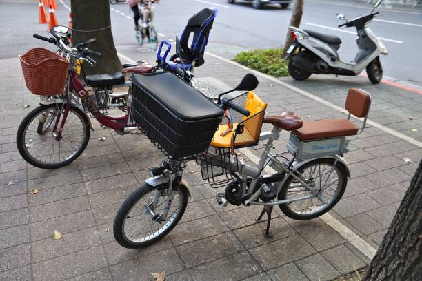 Three person electric bicycle in Taipei, Taiwan. All sorts of multi-person bicycles are popular means of transportation for mothers to deliver children to school.