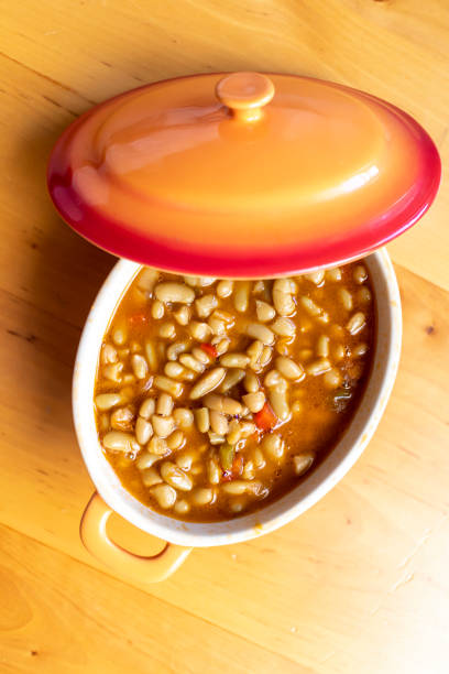 Asturian bean stew, beans with seafood Asturian clam and bean stew served in an orange bowl. Spanish Cuisine. Selective focus. Fabes with seafood. fabes stock pictures, royalty-free photos & images