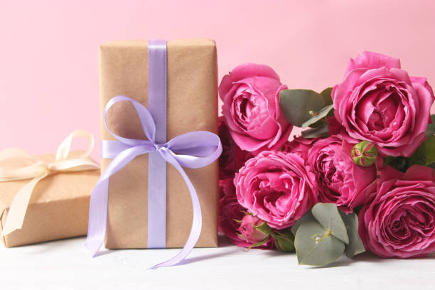 istock gift and flowers on a colored background. Holiday, give a gift, congratulations 1314741340