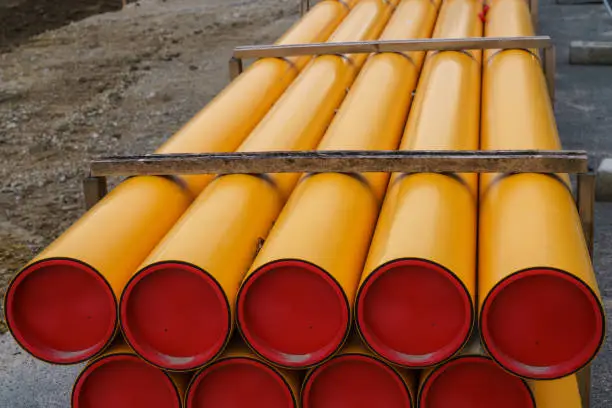 Construction site. Stacks of orange-yellow PVC electrical conduit pipes.