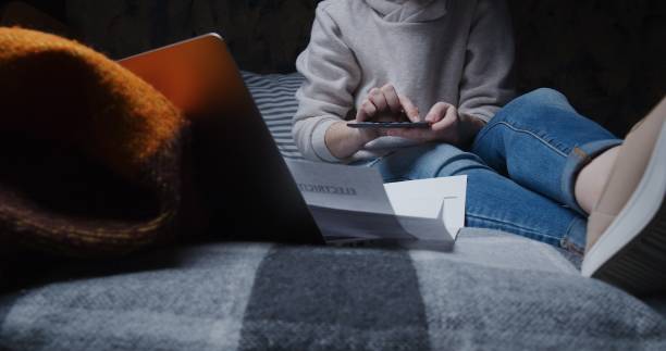 istock Woman is sitting on sofa and counting her home finances 1314742353