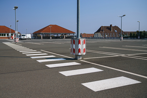 Pedestrian zebra crossing in an empty parking lot on the roof of a supermarket. Clear sunny day.