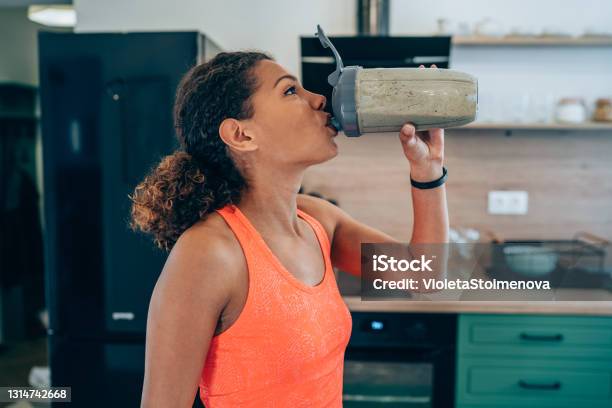 Young Woman Drinking Protein Shake After Workout At Home Stock Photo - Download Image Now