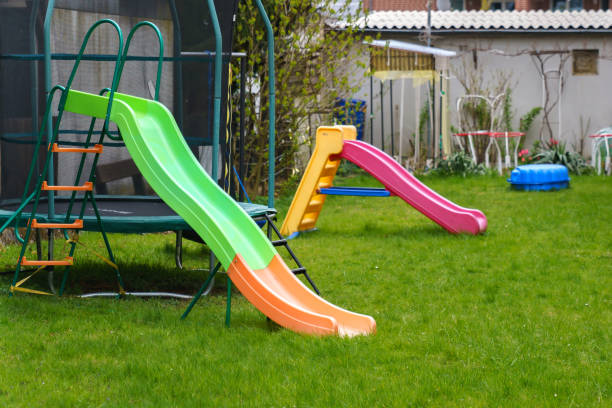 istock Plastic multi-colored slides on the playground. Green grass on the lawn. 1314742836