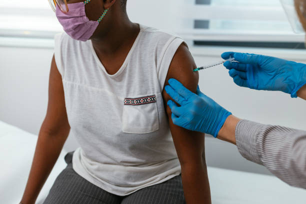 istock Nurse applying vaccine on black patient's arm 1314744028