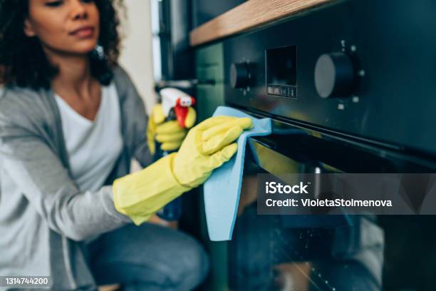 Woman Wiping Surface At Home Stock Photo - Download Image Now - Housework, Cleaning, Oven