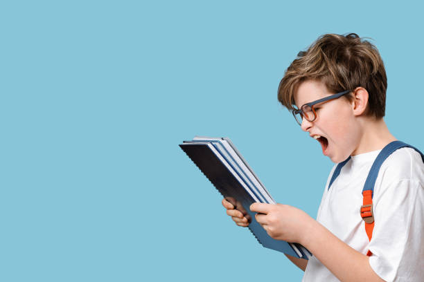 istock Surprised or outraged school boy looking at notepad or test grade 1314746924