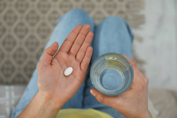 young woman with abortion pill and glass of water, top view - birth control pill imagens e fotografias de stock