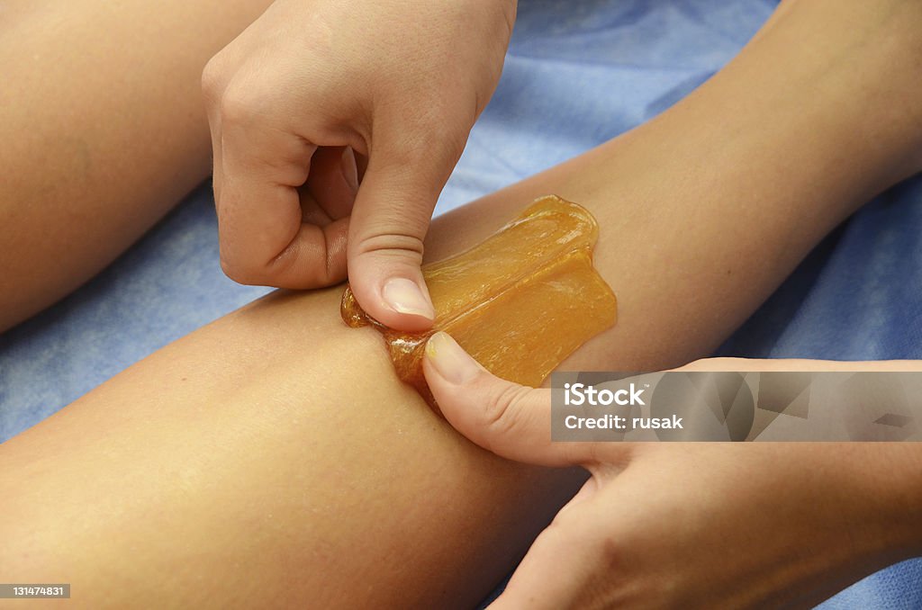 sugaring hair removal Sugaring: epilation with liquate sugar at legs. Adult Stock Photo