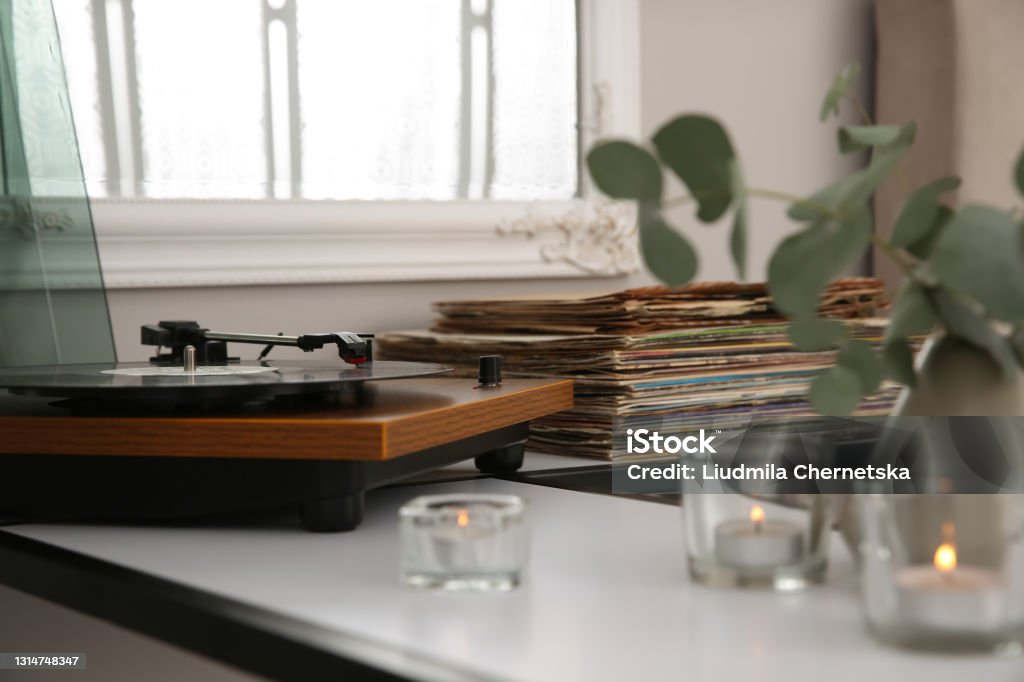 Stylish turntable with vinyl record on table indoors Turntable Stock Photo