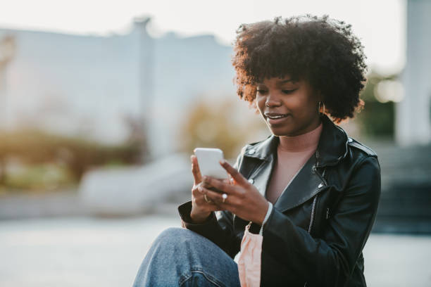 istock A young afro woman using her phone outside 1314754110