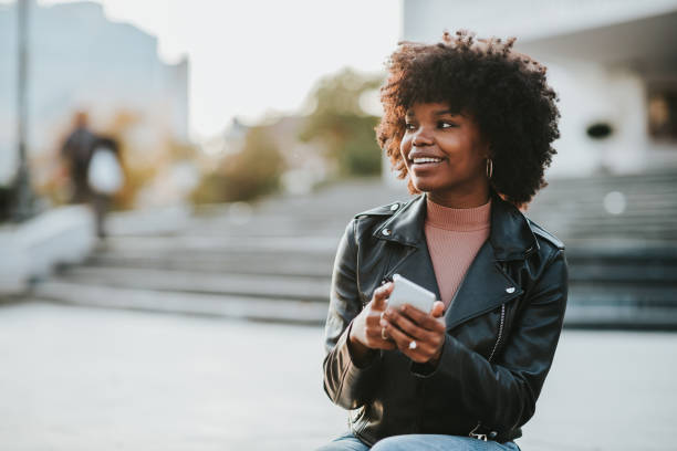istock Young afro woman using phone while she is out in the city 1314754466