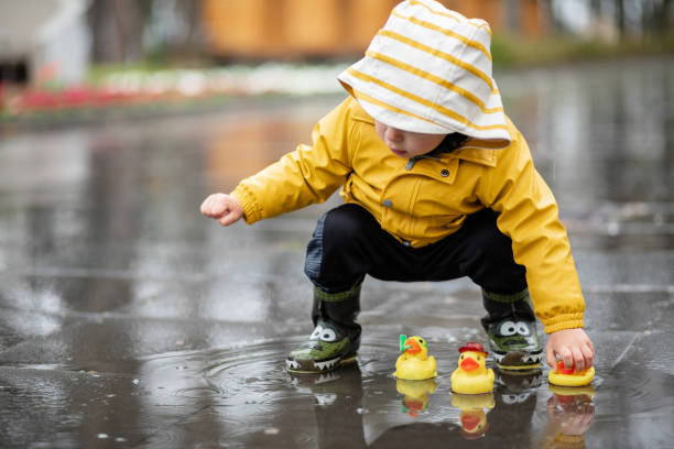 istock Child playing with rubber ducks in water puddle 1314757673