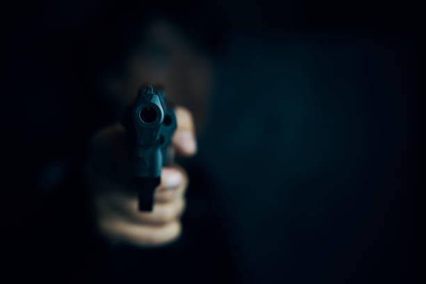 istock Muzzle of gun in man's hand is pointed at camera. 1314758305