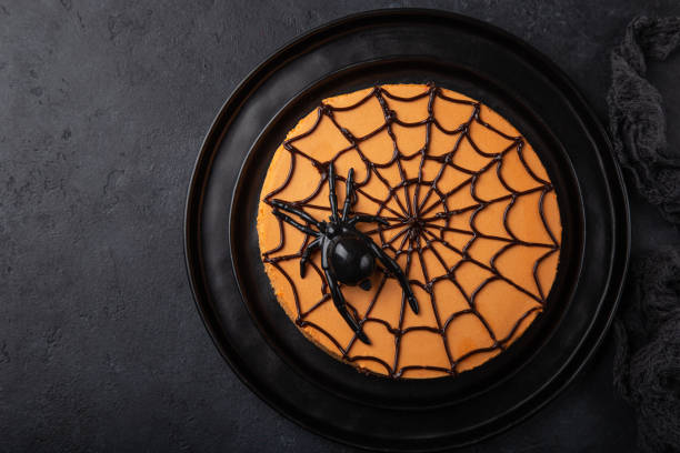 Halloween pumpkin cheesecake, black background, top view