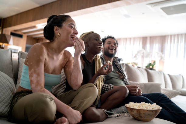 amigos juntos viendo la televisión en casa - watching tv fotografías e imágenes de stock