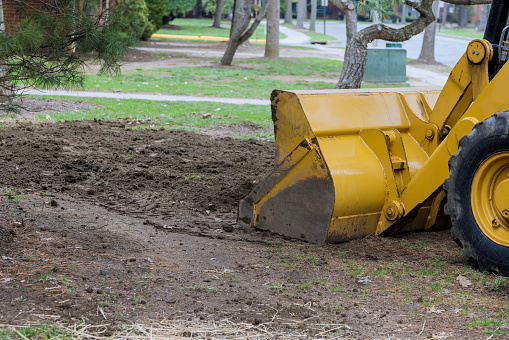 Small tractor digging land working with land level the ground