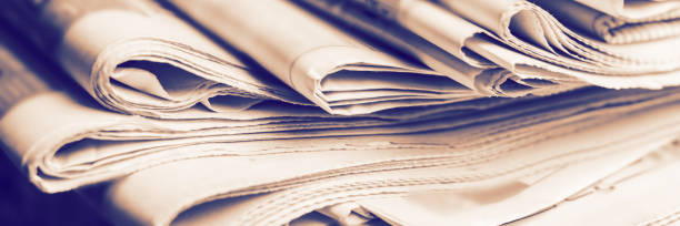 A stack of old newspapers. Media news concept. Panoramic image. Soft focus.