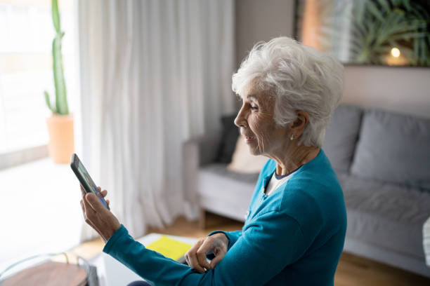 istock Senior woman doing a video call on mobile at home 1314771891