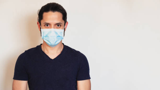 istock Young latin man wearing a face mask on a clear background 1314774334