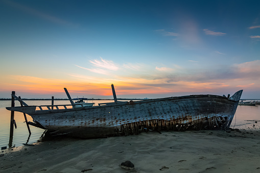 A broken old wooden fishing boat abandoned at Dammam Corniche, Kingdom of Saudi Arabia.