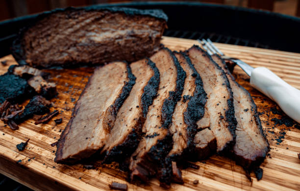 Brisket on a Cutting Board A hand sliced Brisket on a wood cutting board. brisket photos stock pictures, royalty-free photos & images