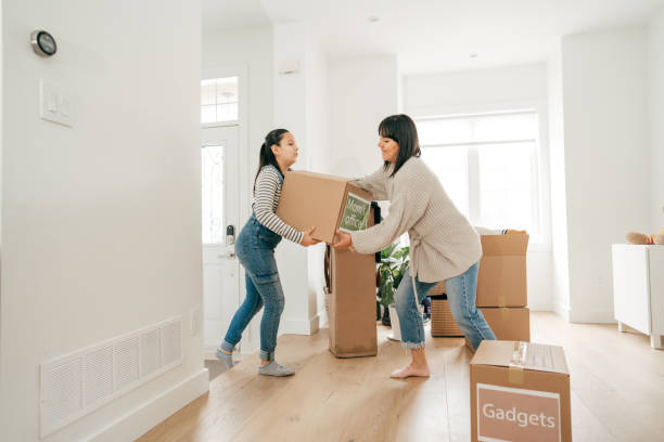 istock Mom and daughter moving boxes into new house 1314779054
