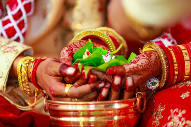 groom and bride holding green leaf and lord Ganesha sculpture in hand groom and bride holding green leaf and lord Ganesha sculpture in hand culture of india photos stock pictures, royalty-free photos & images