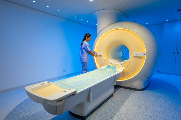 istock Nurse operating with examination machine in blue illuminated hospital room. 1314783965