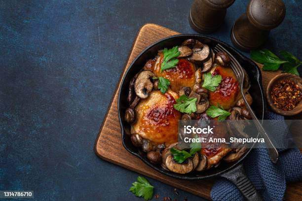 Roasted Chicken Thighs With Mushrooms On Cast Iron Pan Stock Photo - Download Image Now
